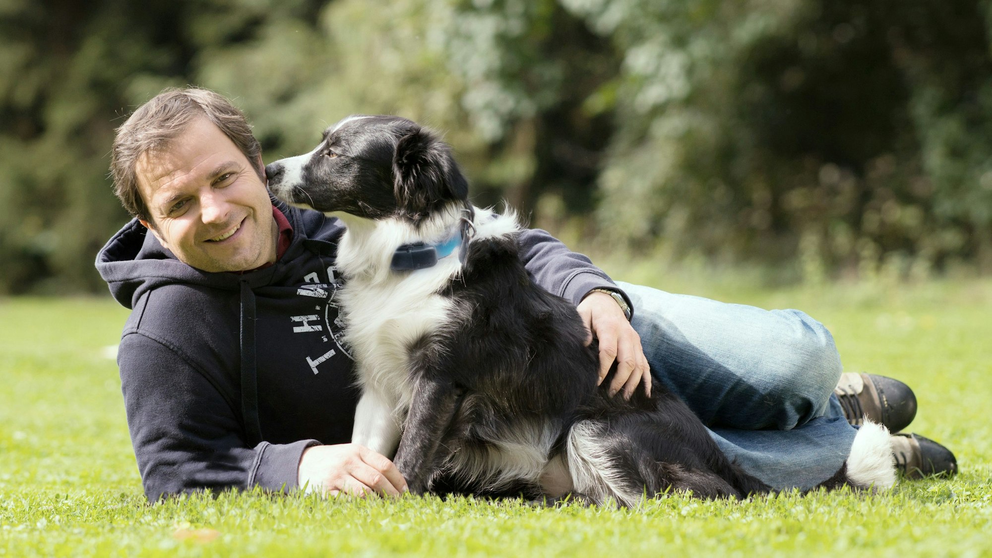 Hundeprofi Martin Rütter liegt mit einem Hund auf einer Wiese. Das Bild wurde am neunten Oktober 2020 aufgenommen.