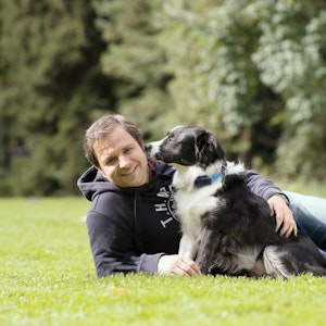 Hundeprofi Martin Rütter liegt mit einem Hund auf einer Wiese. Das Bild wurde am neunten Oktober 2020 aufgenommen.