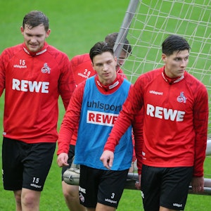 Luca Kilian, Noah Katterbach und Sava Cestic gehen im Training des 1. FC Köln über den Rasen.