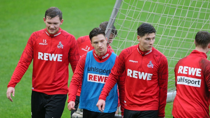 Luca Kilian, Noah Katterbach und Sava Cestic gehen im Training des 1. FC Köln über den Rasen.