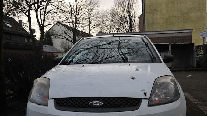Auf der Motorhaube eines Ford Fiestas sieht man mehrere Einschusslöcher.