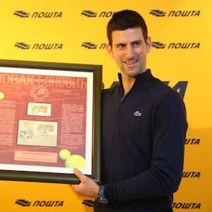 Novak Djokovic zeigt seine Briefmarke der serbischen Post.