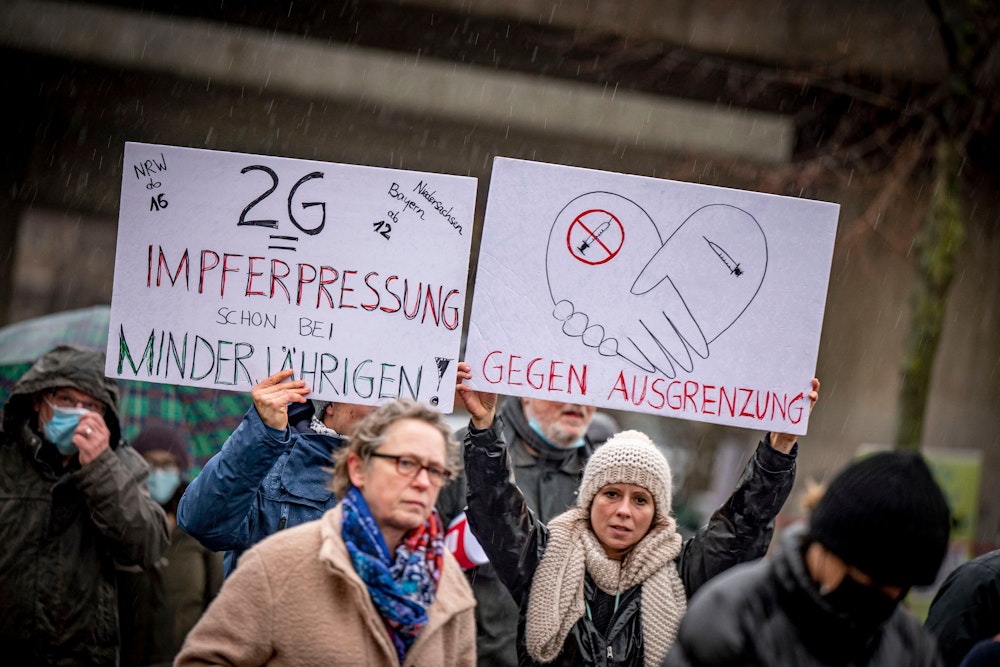 Proteste gegen die Corona-Maßnahmen in Düsseldorf: Teilnehmer halten am 8. Januar 2022 Schilder hoch.