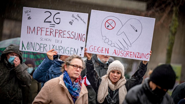 Proteste gegen die Corona-Maßnahmen in Düsseldorf: Teilnehmer halten am 8. Januar 2022 Schilder hoch.
