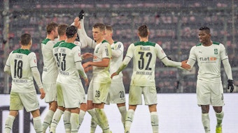 Spieler von Borussia Mönchengladbach klatschen sich beim Rückrunden-Auftaktsieg bei Bayern München (7. Januar 2022) in der Allianz-Arena ab. Zu sehen sind Profis wie Matthias Ginter, Florian Neuhaus oder Stefan Lainer.