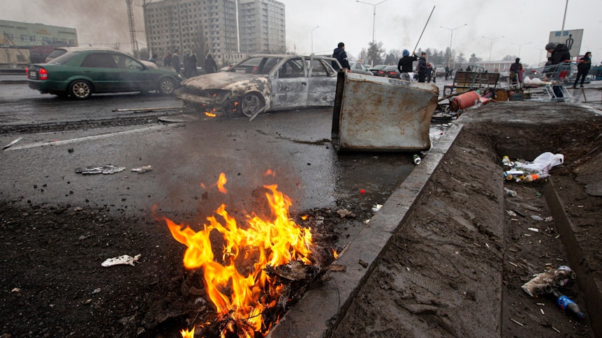 Die Straßen in Almaty gleichen einem Schlachtfeld: Menschen laufen am 7. Januar an ausgebrannten Autowracks vorbei. Seit Wochen herrscht Chaos in dem Land.