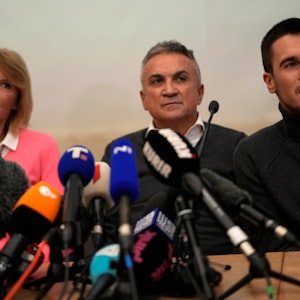 Die Familie von Novak Djokovic sitzt bei einer Pressekonferenz am Rednerpult.
