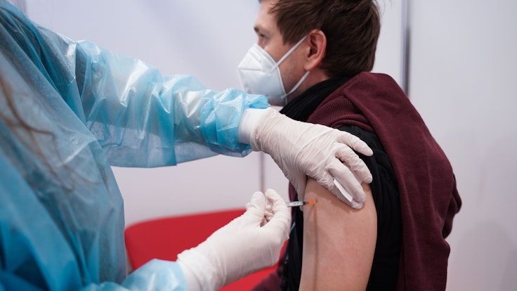 Ein junger Mann wird Ende Dezember in Potsdam mit einer Booster-Dosis des Impfstoffs von Moderna in Potsdam geimpft.