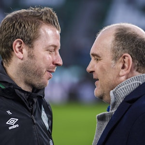 Florian Kohfeldt und Jörg Schmadtke unterhalten sich vor einem Bundesliga-Spiel.