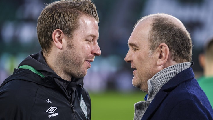 Florian Kohfeldt und Jörg Schmadtke unterhalten sich vor einem Bundesliga-Spiel.
