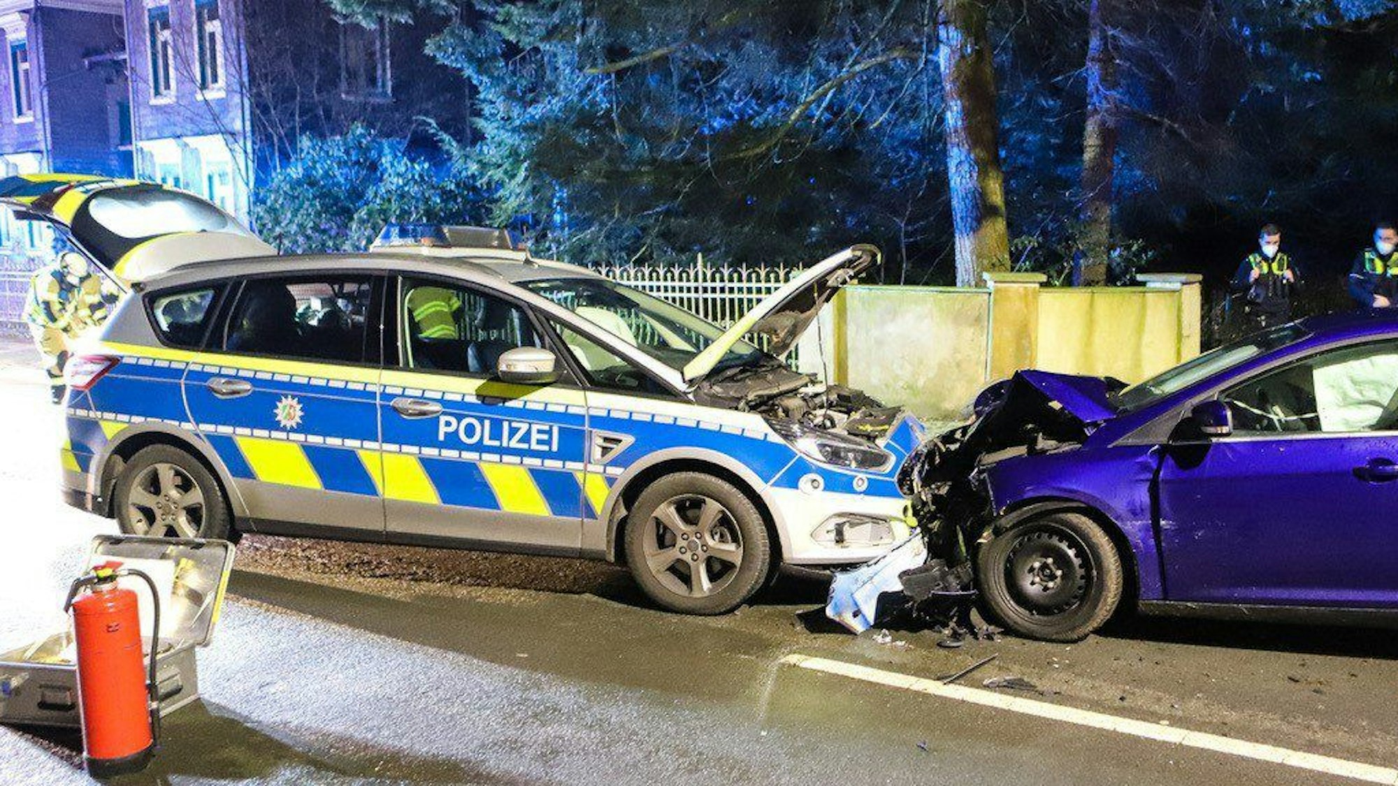 Ein Streifenwagen der Polizei und ein weiteres Auto stehen nach einem Unfall auf einer Straße.