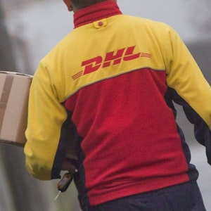 Ein DHL-Paketzusteller liefert am 09.12.2014 in seinem Zustellbezirk in Nürnberg (Bayern) Sendungen aus.