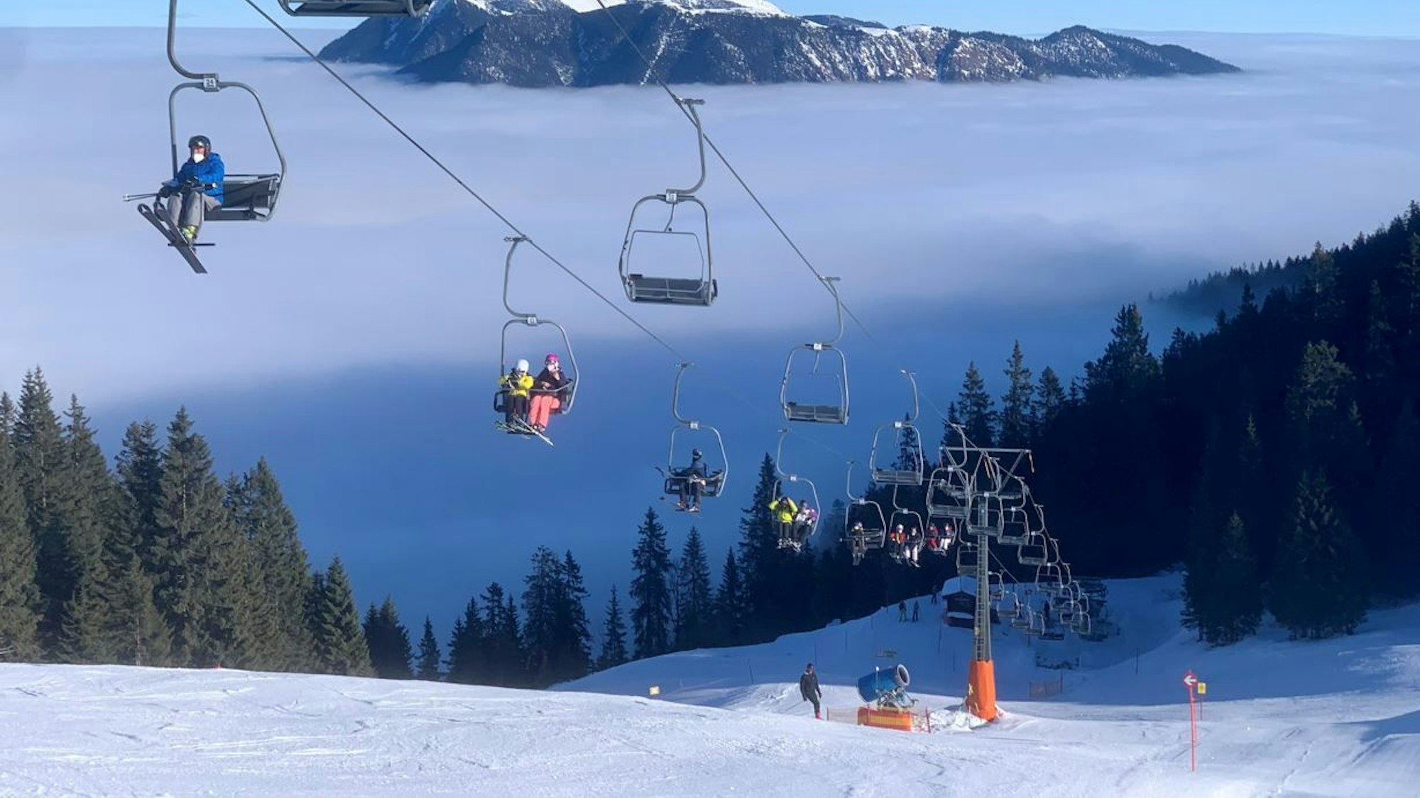 Bayern, Garmisch-Partenkirchen: In einer Sesselbahn am Kreuzeck bei Garmisch-Partenkirchen fahren die ersten Skifahrer der Saison auf den Berg.