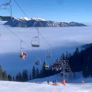 Bayern, Garmisch-Partenkirchen: In einer Sesselbahn am Kreuzeck bei Garmisch-Partenkirchen fahren die ersten Skifahrer der Saison auf den Berg.