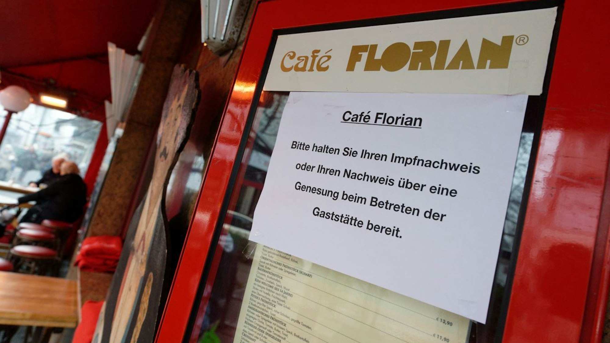 12.01.2022, Nordrhein-Westfalen, Düsseldorf: Ein Schild am Eingang zum Café Florian fordert die Gäste zum bereithalten des Impfnachweises auf.