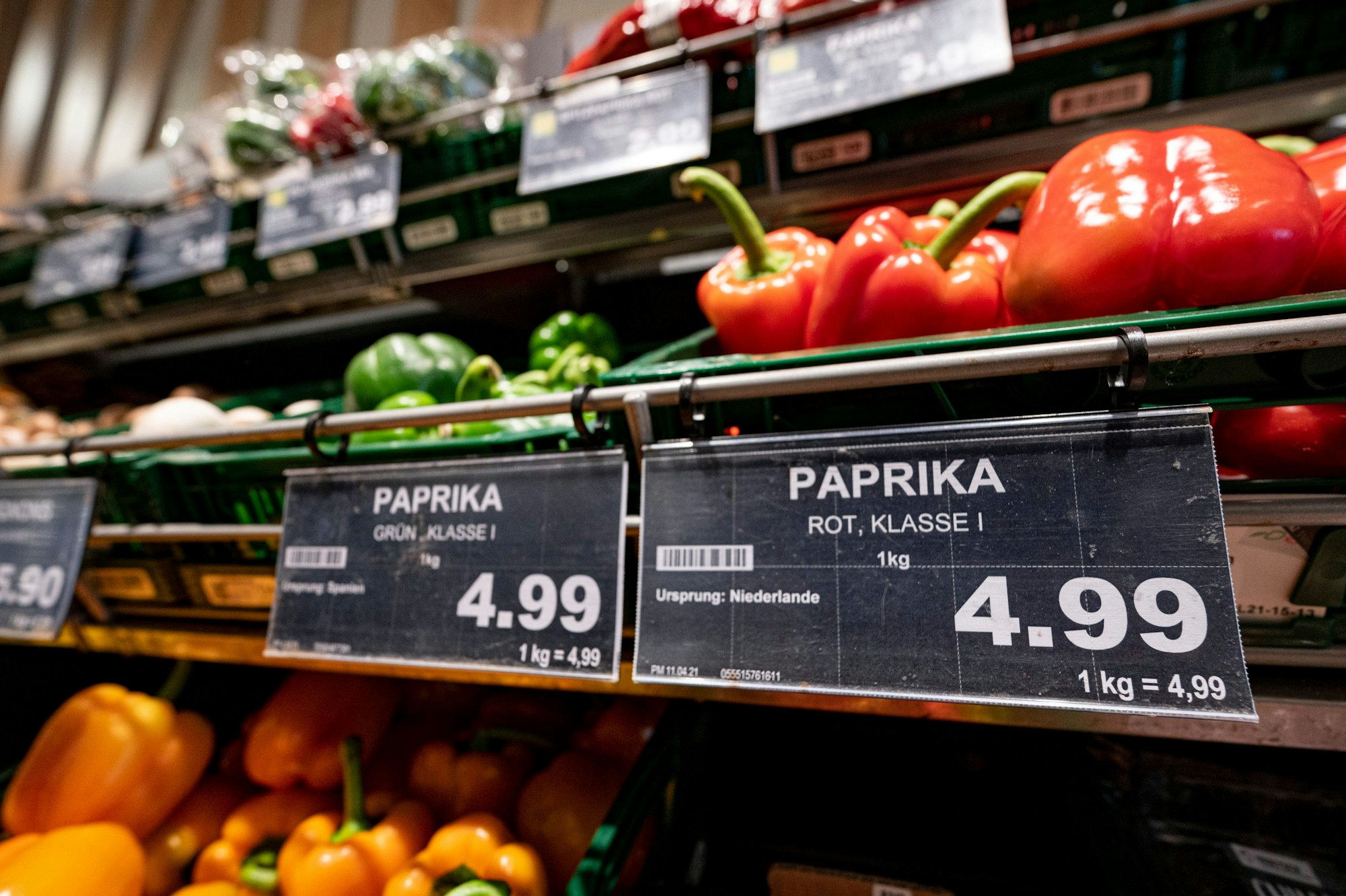 Ein Preisschild von Paprikas hängt an der Obsttheke in einem Supermarkt