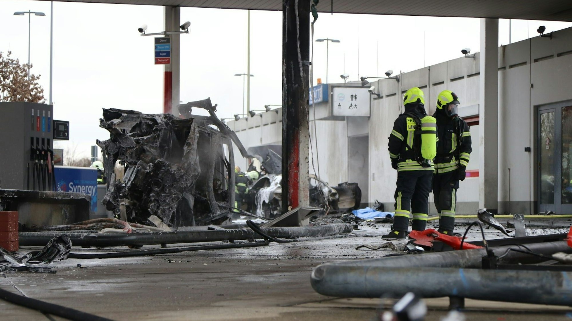 Zwei Feuerwehrleute haben das Feuer an der Tankstelle an der AutobahnraststätteLangen-Bergheim am 17. Januar 2022 gelöscht. Auf dem Bild sieht man einen ausgebrannten PKW.