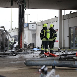 Zwei Feuerwehrleute haben das Feuer an der Tankstelle an der Autobahnraststätte Langen-Bergheim am 17. Januar 2022 gelöscht. Auf dem Bild sieht man einen ausgebrannten PKW.