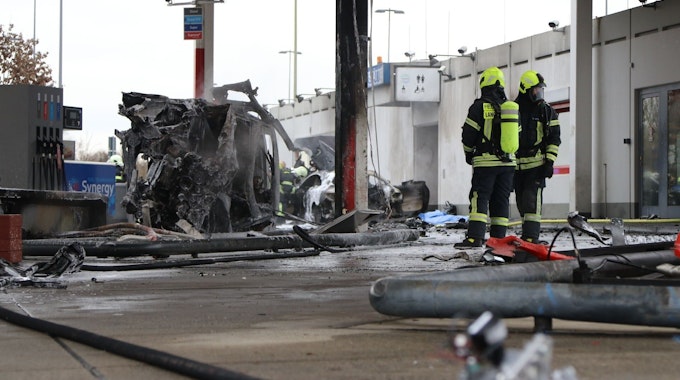Zwei Feuerwehrleute haben das Feuer an der Tankstelle an der Autobahnraststätte Langen-Bergheim am 17. Januar 2022 gelöscht. Auf dem Bild sieht man einen ausgebrannten PKW.