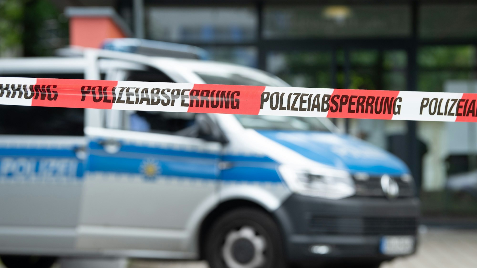 Ein Polizeiauto steht hinter einer Absperrung vor einem Studentenwohnheim im Dresdner Stadtteil Strehlen.