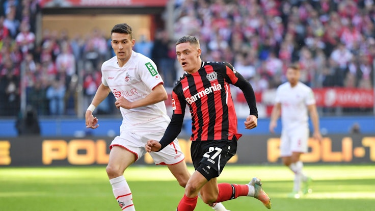 Florian Wirtz führt den Ball, Köln Dejan Ljubicic jagt ihm hinterher.