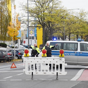 Polizei-Auto und Polizisten auf einer Straße in Köln-Sülz.