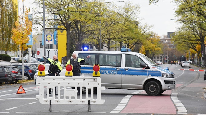 Polizei-Auto und Polizisten auf einer Straße in Köln-Sülz.