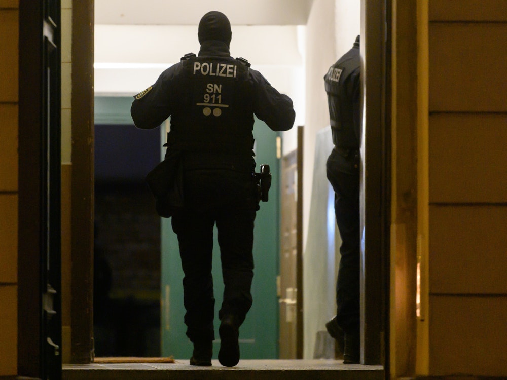 Polizisten stehen während einer Razzia in einem Haus im Stadtteil Dresden-Pieschen.