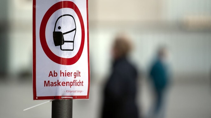Solingen: In der Innenstadt weist ein Schild auf die Maskenpflicht hin.