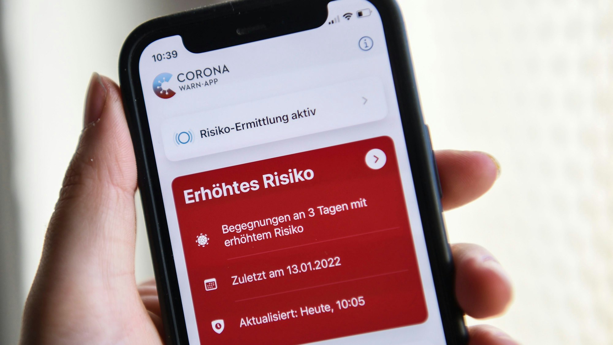 Berlin: Auf einem Smartphone zeigt die geöffnete Corona-Warn-App ein erhöhtes Risiko an. Die rote Anzeige warnt vor drei Begegnungen mit Corona-positiv getesteten Personen.