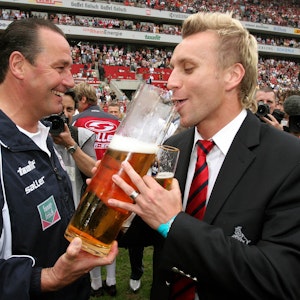 Trainer Huub Stevens (li.) verleitet Sebastian Schindzielorz (beide Köln) während der Aufstiegsfeier zum Bier trinken.
