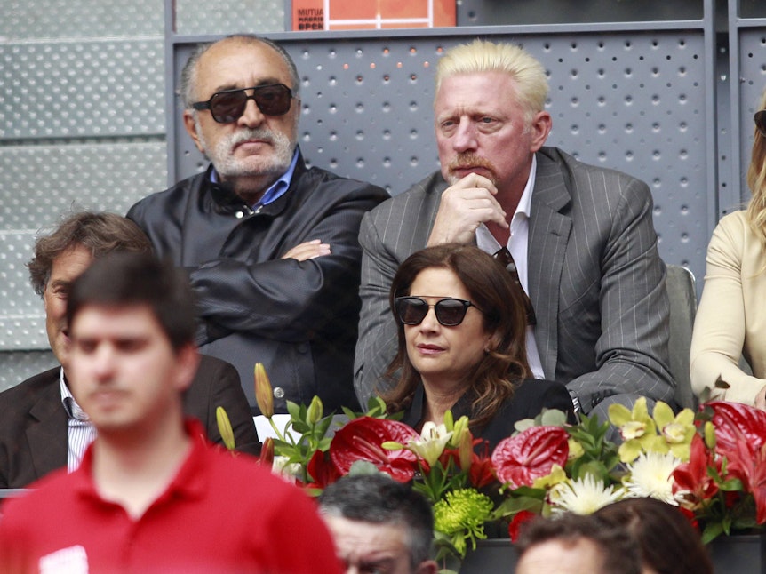 Ion Tiriac (l) und Boris Becker sitzen beim Tennis auf der Tribüne.