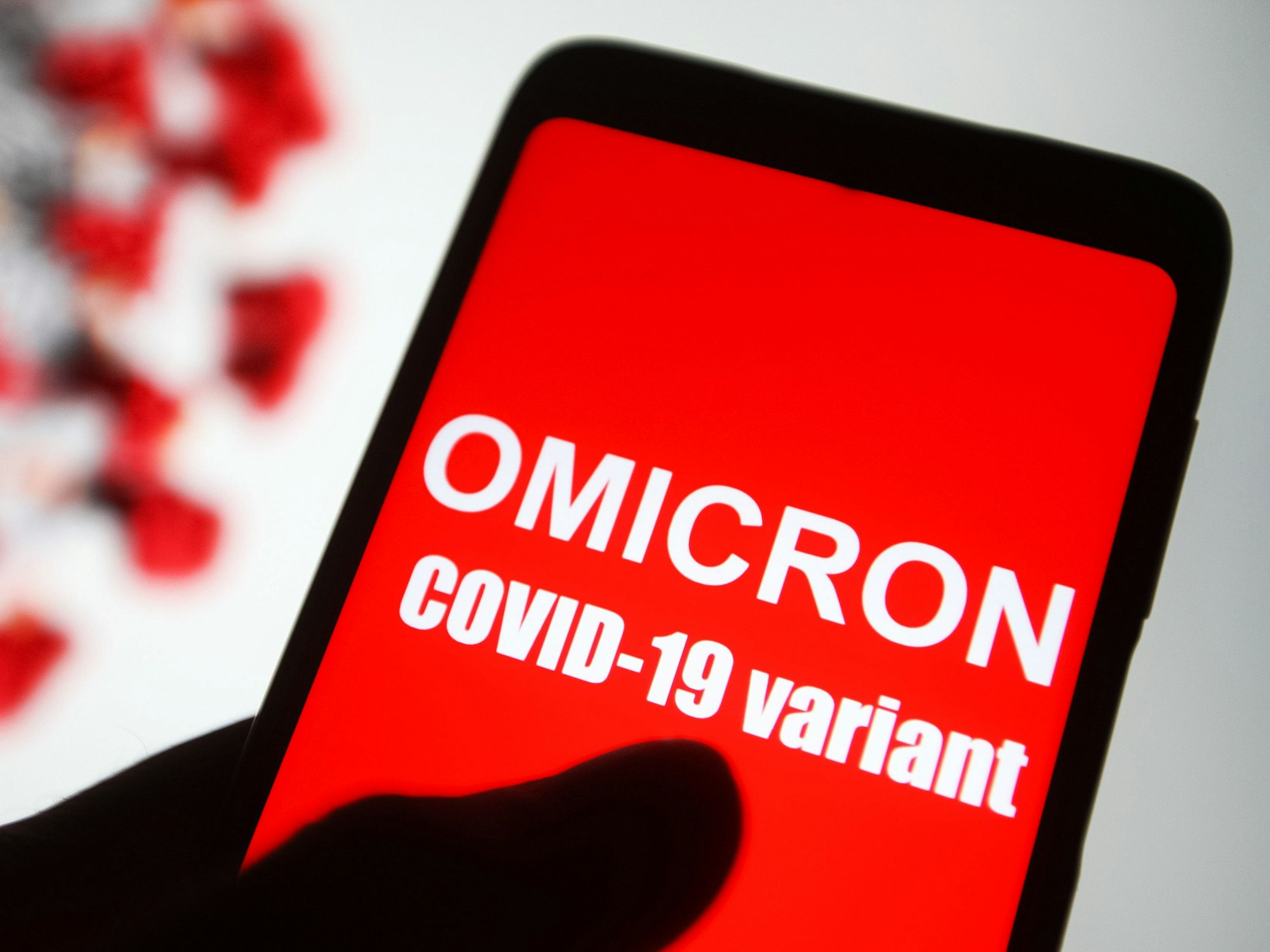 Auf dem Bildschirm eines Smartphones ist der Text «Omicron COVID-19-variant» zu lesen.