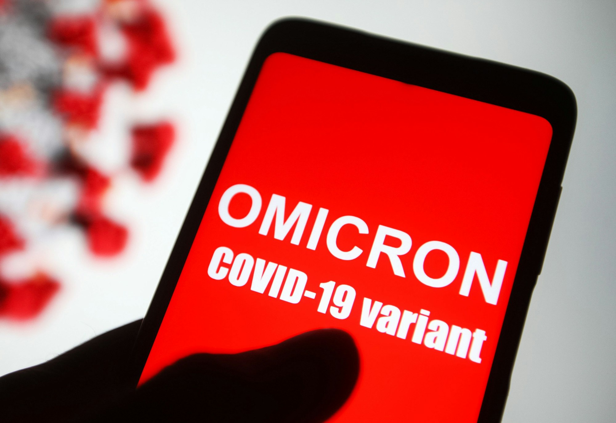 Symbolbild. Auf dem Bildschirm eines Smartphones ist der Text „Omicron COVID-19-variant“ zu lesen.