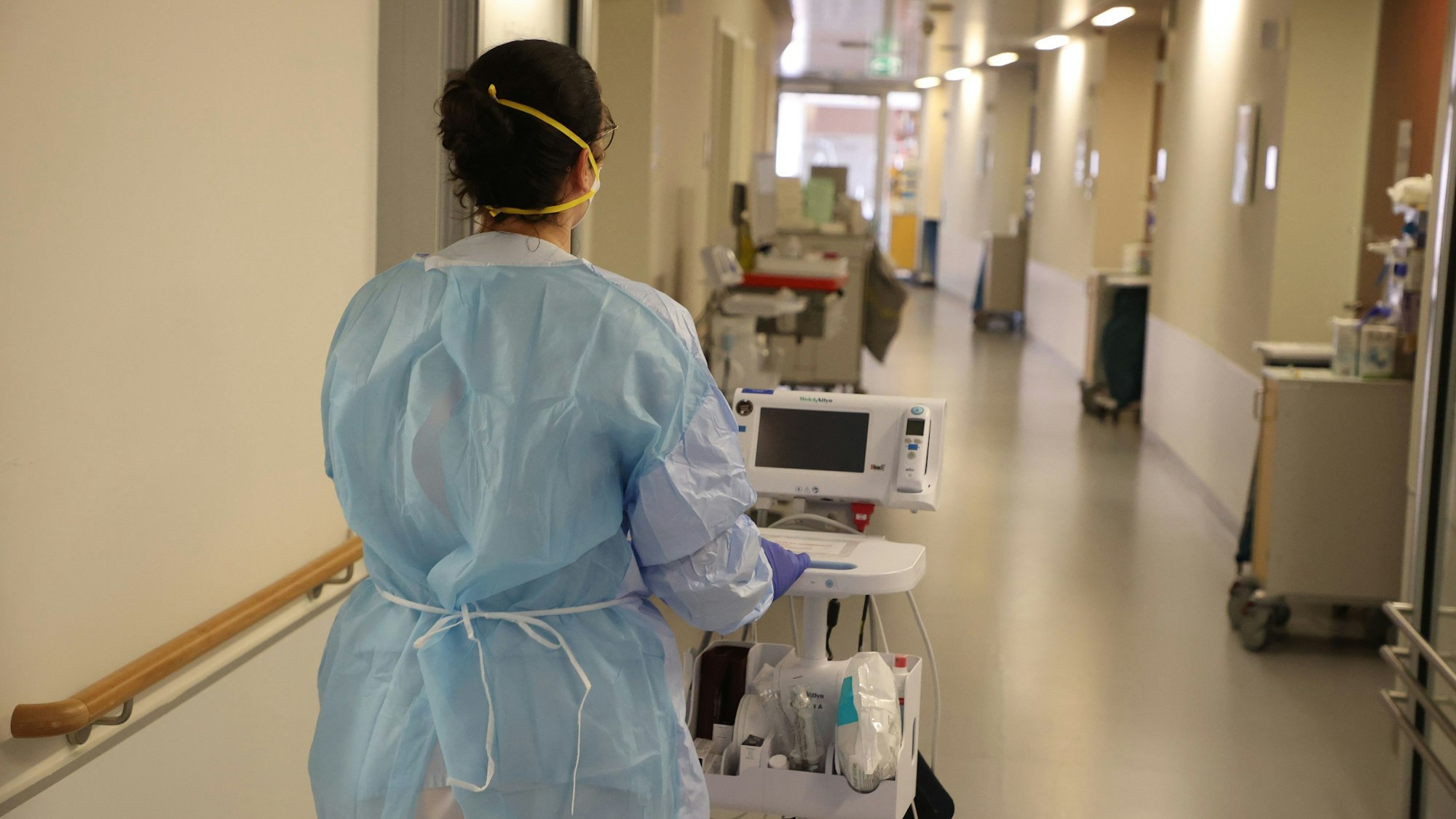 Eine Krankenschwester läuft mit medizinischem Gerät auf dem Flur der Corona-Station im Krankenhaus entlang. Das Bild wurde am 13. Januar 2022 aufgenommen.