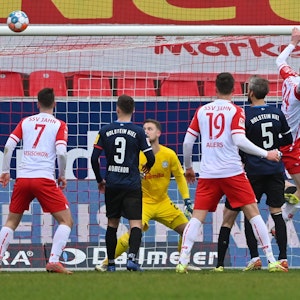 Viele Spieler tummeln sich im Kieler Strafraum. Thomas Dähne schaut dem ins Tor fliegenden Ball nur hinterher.