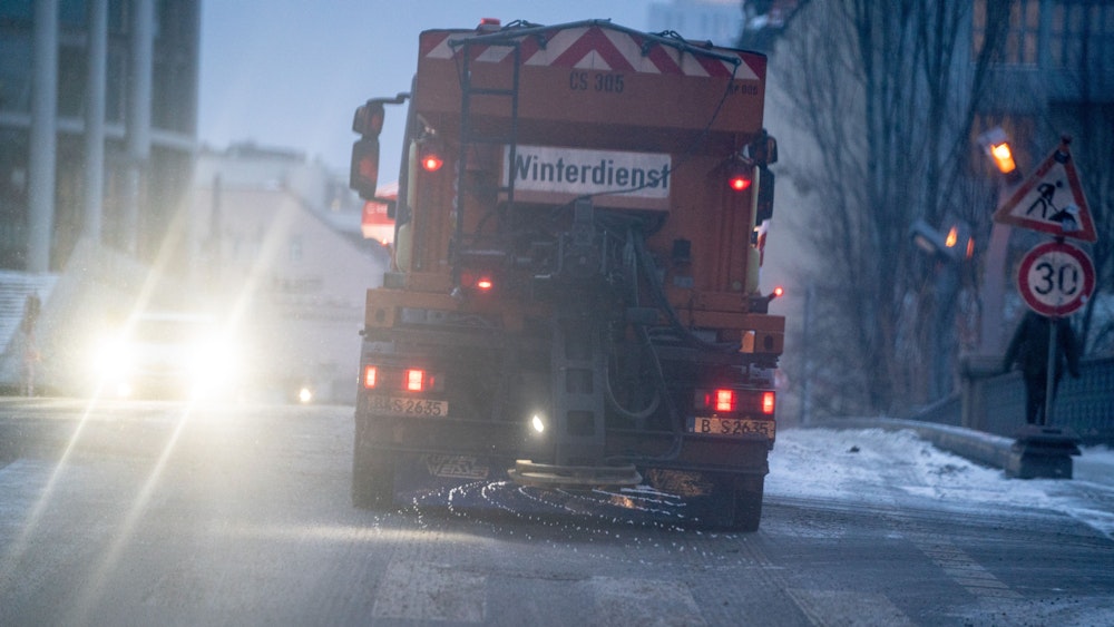 Ein Streufahrzeug des Winterdienstes fährt am Morgen bei eisigen Temperaturen durch Berlin-Mitte.
