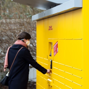 Eine Post-Mitarbeiterin bedient eine neue Poststation. Das Bild entstand am 16. Februar 2021.