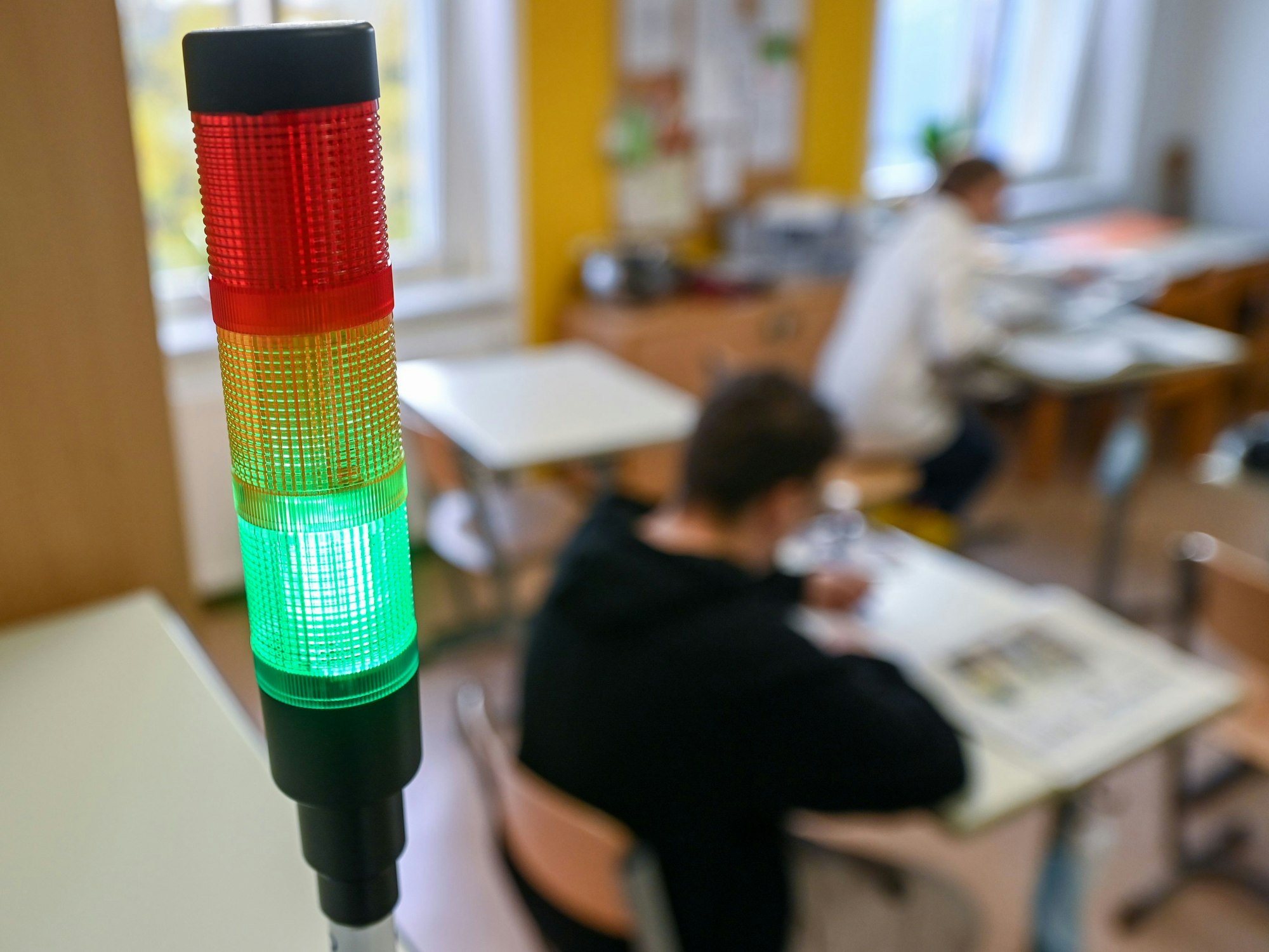 Eine sogenannte Co2-Ampel leuchtet in einem Klassenraum grün.