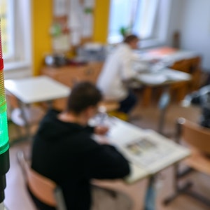 Eine sogenannte Co2-Ampel leuchtet in einem Klassenraum grün.