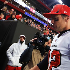 Tom Brady geht vom Feld, trägt eine rote Kappe.