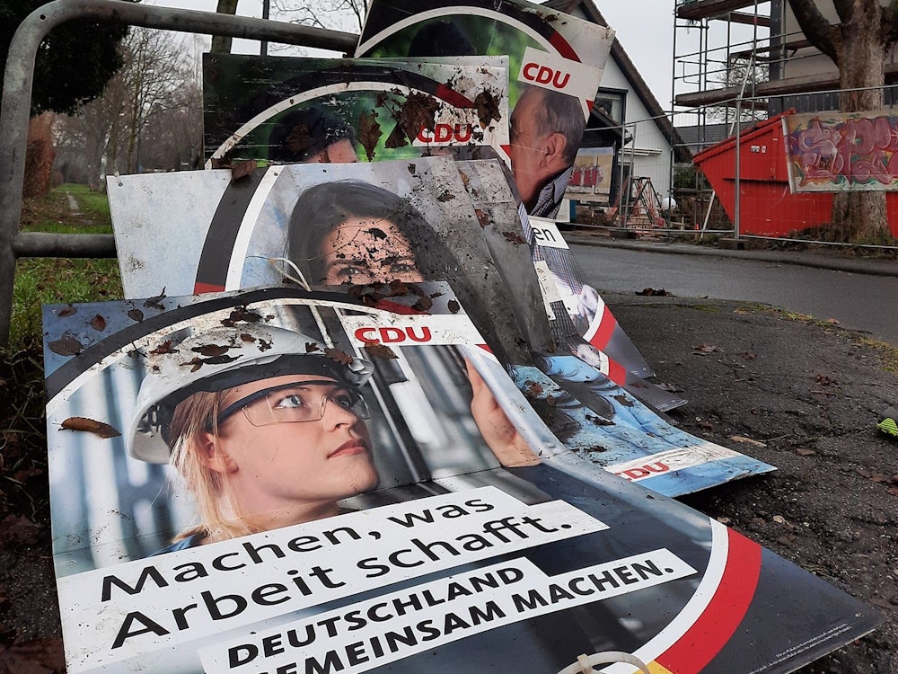 Wahlplakate der CDU liegen am Straßenrand in Köln