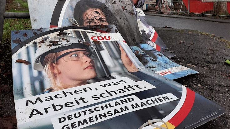 Wahlplakate der CDU liegen am Straßenrand in Köln