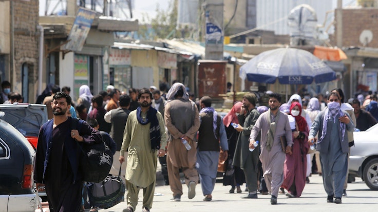 Menschen begeben sich zu einer Militäreinrichtung auf einem Flughafen in Kabul. Foto vom 23. August 2021.