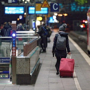 Eine Frau geht am Hauptbahnhof in Köln mit Koffer zu ihrem Zug. Foto von der dpa