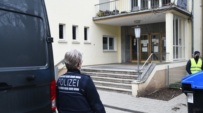 Polizei und Wachschutz stehen am 25. Januar 2022 an dem Eingang zum Gebäude auf dem Gelände der Heidelberger Universität in dem sich der Tatort eines Amoklaufes befindet.