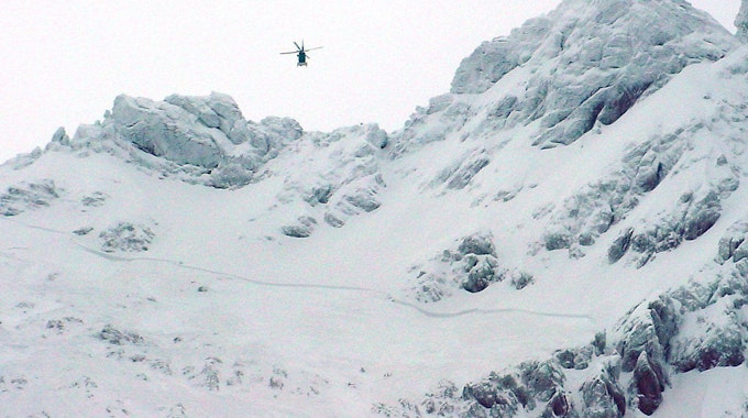 Ein Hubschrauber der bayerischen Bergwacht fliegt am 27. Dezember 2002 über dem Gebiet der Hocheisspitze bei Berchtesgaden. Am Dienstag (25. Januar 2022) starb in dem Gebiet ein 39-jähriger Skitourengeher in einer selbst ausgelösten Lawine.