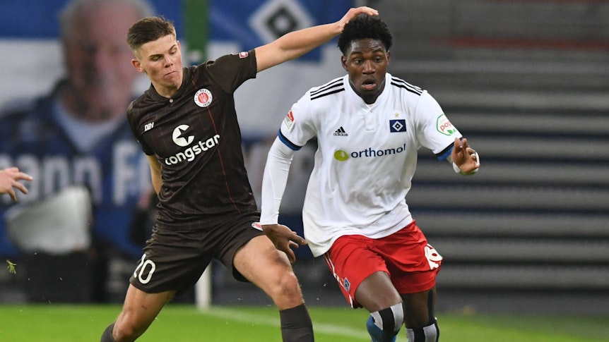 Finn Ole Becker vom FC St. Pauli, hier am 21. Januar 2022 in Hamburg im Zweitliga-Duell mit HSV-Spieler Faride Alidou, soll bei Borussia Mönchengladbach ein Thema sein. Die beiden Spieler kämpfen um den Ball.