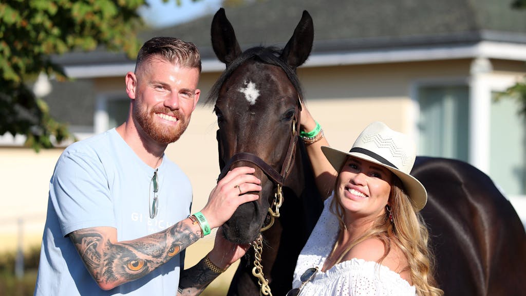 Timo und Carina Horn herzen ein Renn-Pferd bei einer Auktion.