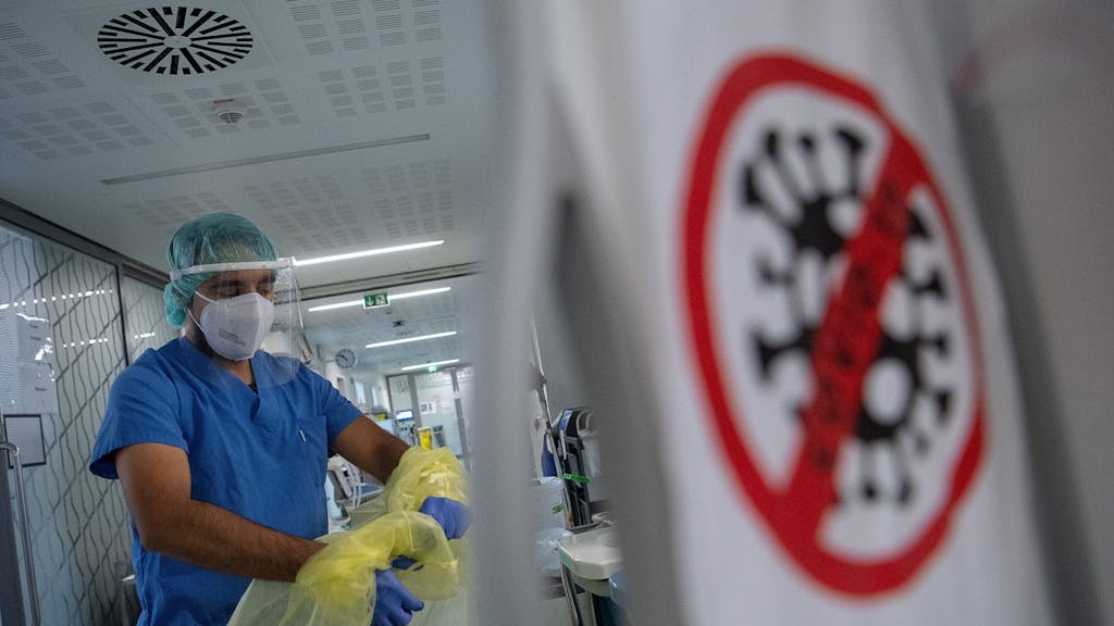 Ein Pfleger zieht beim Verlassen der Intensivstation für Corona-Patienten am Sana Klinikum Offenbach seinen Schutzkittel aus.